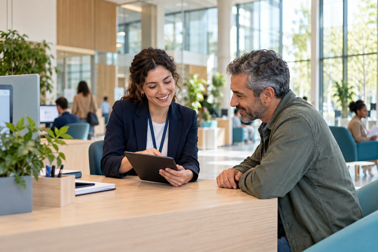 Une agente accueille un usager dans un espace de services publics contemporain et lumineux.